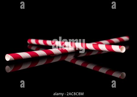 Gruppe von zwei ganze rotes Papier Stroh auf schwarzem Glas isoliert Stockfoto