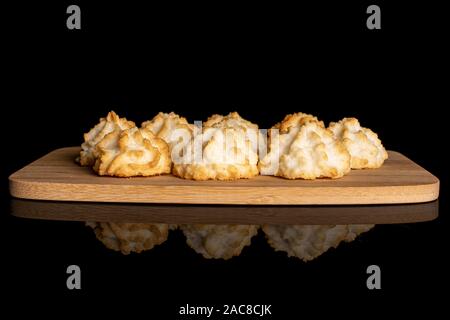 Menge ganze hausgemachte Golden coconut Keks auf Bambus Schneidbrett auf schwarzem Glas isoliert Stockfoto