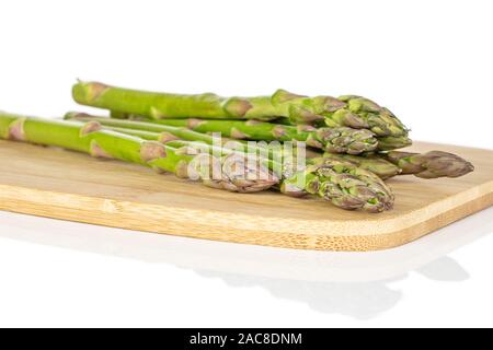 Menge ganz gesunden grünen Spargel auf Bambus Schneidbrett auf weißem Hintergrund Stockfoto