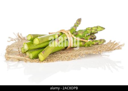 Menge ganz gesunden grünen Spargel mit Stroh Seil und Jutegewebe auf weißem Hintergrund Stockfoto