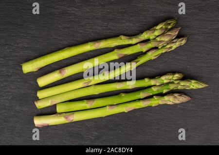 Menge ganz gesunden grünen Spargel flatlay am grauen Stein Stockfoto
