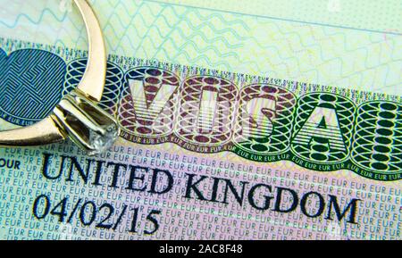 UK Visa Aufkleber in den Reisepass und das Engagement Diamond Ring oben platziert. Konzept Foto für für Partner und Ehepartner Visum GROSSBRITANNIEN. Makro Foto. Stockfoto