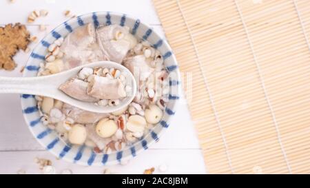 Lecker vier Stärkungsmittel Kraut Geschmack Suppe, Taiwanesische traditionelle Speisen mit Kräutern, schweinedickdarm auf weissem Holztisch, Nahaufnahme, Flach, Ansicht von oben. Stockfoto