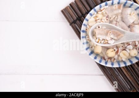 Lecker vier Stärkungsmittel Kraut Geschmack Suppe, Taiwanesische traditionelle Speisen mit Kräutern, schweinedickdarm auf weissem Holztisch, Nahaufnahme, Flach, Ansicht von oben. Stockfoto