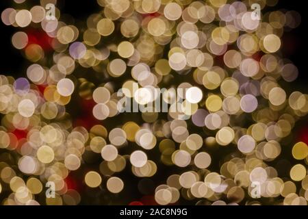 Gold und Rot Weihnachten Licht glänzende abstrakte Runde bokeh auf schwarzem Hintergrund. Bunte Glitzer bokeh von blurry Dekoration Lampen. Stockfoto