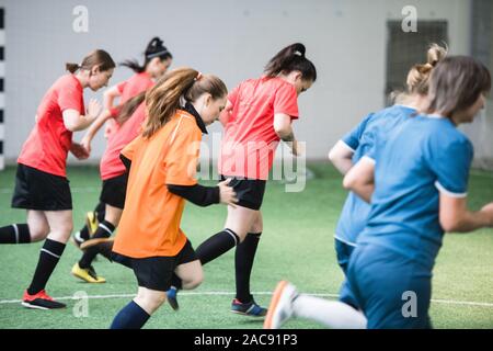 Gruppe von aktiven, weiblichen Fußballer in Sport einheitliche läuft das Feld während Spiel im Stadion Stockfoto