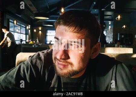 Porträt eines lächelnden gutaussehenden jungen Mann im Cafe Zähler Stockfoto
