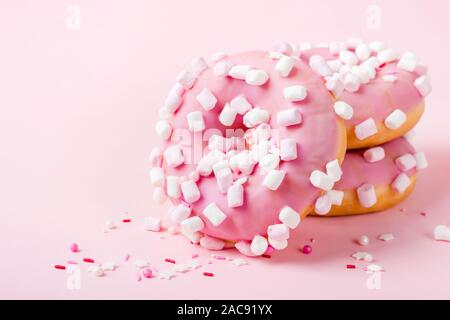 Rosa glasierten Krapfen mit Marshmallows auf rosa Hintergrund close-up. Stockfoto