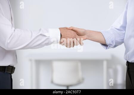 Die Hände der jungen Geschäftspartner Begrüßung durch das Treffen oder nach der Aushandlung und Unterzeichnung des Vertrages Stockfoto