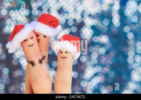 Finger Kunst der Familie feiert Weihnachten. Konzept einer Gruppe von Menschen Lächeln im neuen Jahr Hüte. Stockfoto