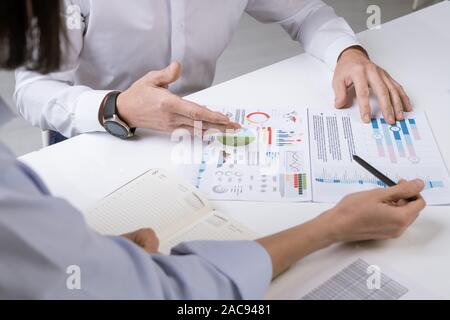 Hände von zwei Financial Manager über Dokumente während der Diskussion der Diagramme, Schaubilder und Diagramme an Arbeitstreffen Stockfoto