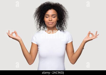 Ruhige friedliche Afrikanische amerikanische Frau meditieren mit geschlossenen Augen Stockfoto