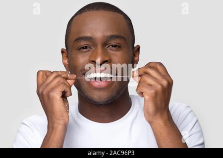 Gerne afrikanische amerikanische Mann mit gesunden Lächeln mit Zahnseide Stockfoto