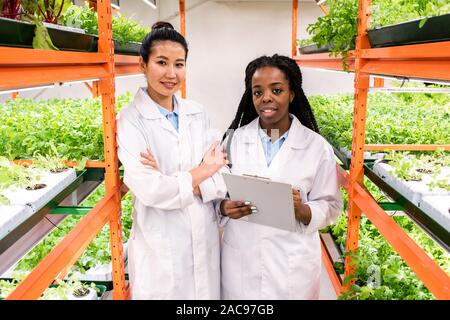 Einer der beiden jungen weiblichen Agronomen Notizen während des Studiums neue Anlagen Stockfoto