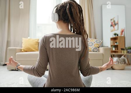 Ansicht der Rückseite Frau mit Dreadlocks, entspannende Musik im Kopfhörer vorhören Stockfoto