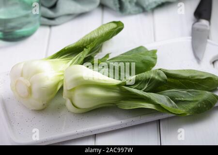 Bok Choy, die Vielfalt der Chinakohl auch bekannt als Pak Choi, Pok Choi, auf einem weißen Schneidebrett Stockfoto