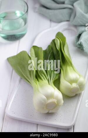 Bok Choy, die Vielfalt der Chinakohl auch bekannt als Pak Choi, Pok Choi, auf einem weißen Schneidebrett Stockfoto