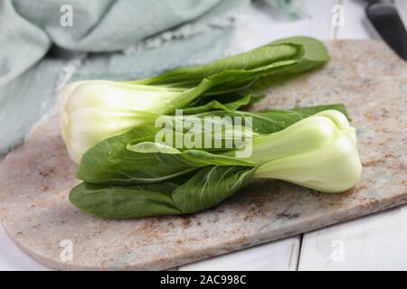 Bok Choy, die Vielfalt der Chinakohl auch bekannt als Pak Choi, Pok Choi, auf einem Marmor Schneidebrett Stockfoto