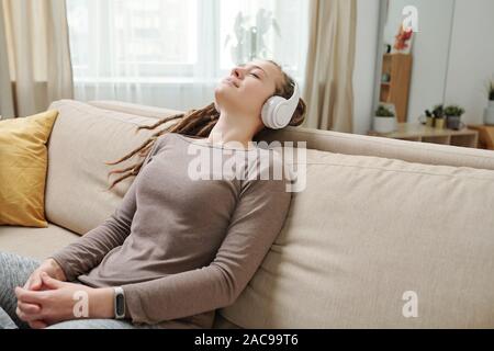 Glückliche junge entspannt Frau mit Kopfhörer hören Meditation Musik Stockfoto
