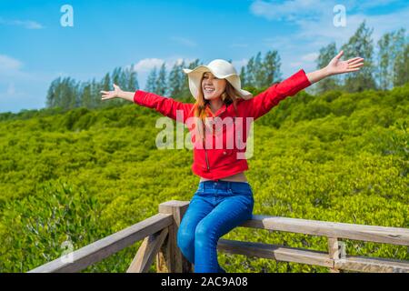 Frau mit der Waffe in der holzbrücke am Tung Prong Tanga oder Golden Mangroven Gebiet, Provinz Rayong, Thailand angehoben Stockfoto