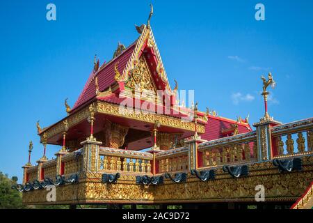 Eine schöne buddhistische Pagode mit vergoldeten Ornamenten und Details. Auf dem Perimeter dunkle Köpfe der Elefanten sind. Das Dach ist rot. Blue Clear Sky. Stockfoto