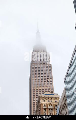 Das Empire State Building in den Wolken, West 33rd Street, New York City, Vereinigte Staaten von Amerika. Stockfoto