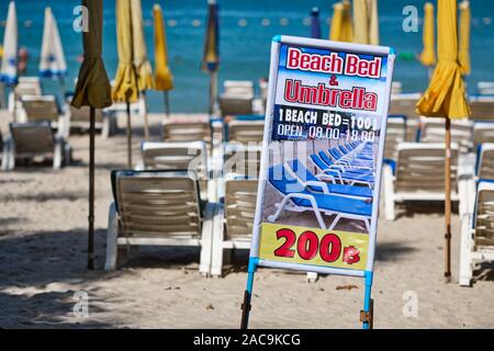 Ein Schild am Patong Beach Werbung vermietung Liegestühle und Sonnenschirme am Strand Stockfoto