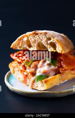 Hausgemachte Speisen Konzept Organische bolognese Grill Artisan Brot Sandwich auf schwarzen Hintergrund mit Kopie Raum Stockfoto