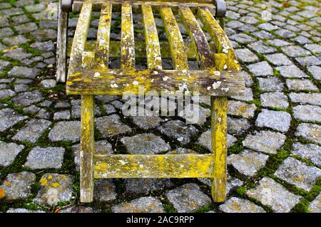 Liegestuhl wit Patina, Flechten und Moos auf einem Kreis aus Steinen Stockfoto