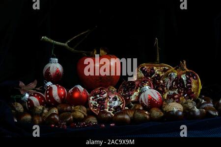 Herbst Früchte mit Weihnachten Kugeln auf schwarzem Hintergrund Stockfoto