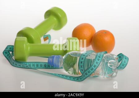 Hanteln in grüner Farbe, Flasche Wasser, Maßband und Obst auf weißem Hintergrund. Sport und gesunde Regime. Barbells aus Kunststoff in der Nähe von saftigen Orangen. Athletik und Gewicht-verlust-Konzept Stockfoto