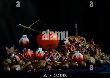 Herbst Früchte mit Weihnachten Kugeln auf schwarzem Hintergrund Stockfoto