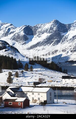 Traditionelle norwegische Holzhaus stand am Ufer auf den Fjord und die Berge in der Ferne. Lofoten. Norwegen. World Travel Stockfoto