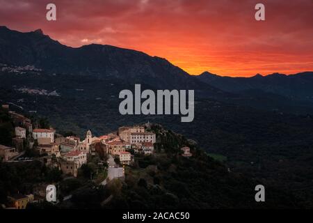 Dramatische orange Sonnenuntergang über dem Bergdorf Belgodere in der Balagne Korsika Stockfoto