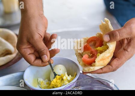 Einfach und lecker Essen. Frisches Fladenbrot gefüllt mit Ei und Tomaten-, Gewürz- und Olivenöl. Stockfoto