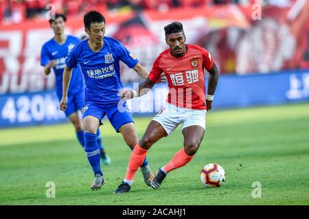 Brasilianische Fußballspieler Paulinho von Guangzhou Evergrande Taobao F.C., rechts, schützt den Ball in der 30. Runde der Chinese Football Association Super League (CSL) gegen Grönland Shanghai Shenhua in Guangzhou City, die südchinesische Provinz Guangdong, 1. Dezember 2019. Guangzhou Evergrande Taobao zerschnitten Shanghai Shenhua Grönlands mit 3-0. Stockfoto