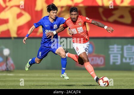 Brasilianische Fußballspieler Paulinho von Guangzhou Evergrande Taobao F.C., rechts, schützt den Ball in der 30. Runde der Chinese Football Association Super League (CSL) gegen Grönland Shanghai Shenhua in Guangzhou City, die südchinesische Provinz Guangdong, 1. Dezember 2019. Guangzhou Evergrande Taobao zerschnitten Shanghai Shenhua Grönlands mit 3-0. Stockfoto