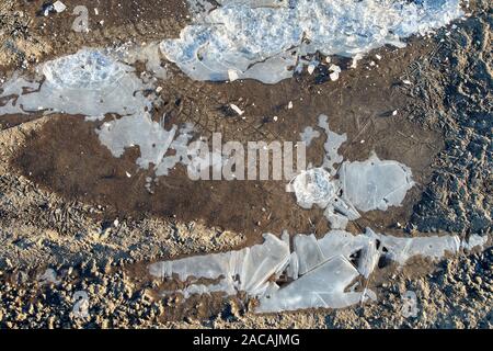 Schmierspuren auf gefrorenem Boden. Schmutz. Eis. Stockfoto