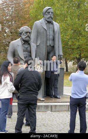 Asiatische Touristen fotografieren sich selbst vor der Statuen von Karl Marx und Friedrich Engels in der so Marx/Engels namens Stockfoto