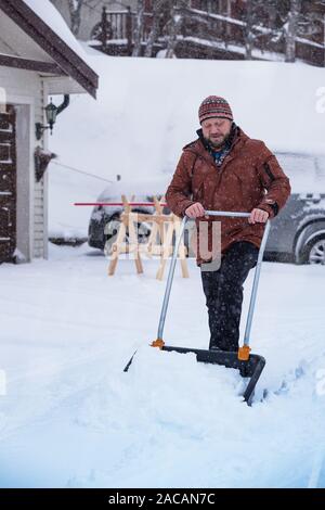 Winter und Schnee. man Schnee reinigt mit einer Schaufel Stockfoto