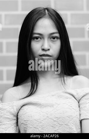 Gesicht der jungen schönen asiatischen Teenager gegen Mauer Stockfoto