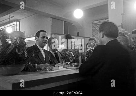 Messegänger begutachten einen Internet-adr., Leipzig, Sachsen, Deutschland, 1948. Die Messe Besucher untersuchen, einen Messestand, Leipzig, Sachsen, Deutschland, 1948. Stockfoto