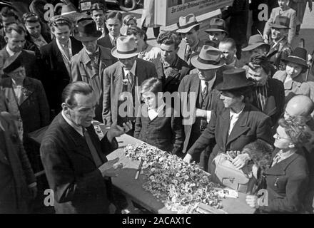 Messegänger begutachten einen Internet-adr., Leipzig, Sachsen, Deutschland, 1948. Die Messe Besucher untersuchen, einen Messestand, Leipzig, Sachsen, Deutschland, 1948. Stockfoto