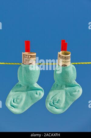 Baby Socken auf die Wäscheleine mit Dollar Banknoten Stockfoto