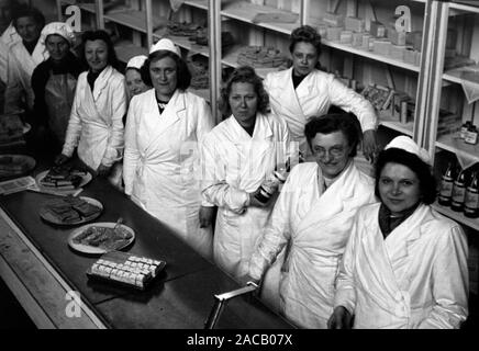 1 Frauen stehen eine 1963 Stand der Süßigkeiten präsentiert, Leipzig Deutschland 1949. Einige Frauen an einem stand präsentiert einige Süßigkeiten, Leipzig 1949. Stockfoto