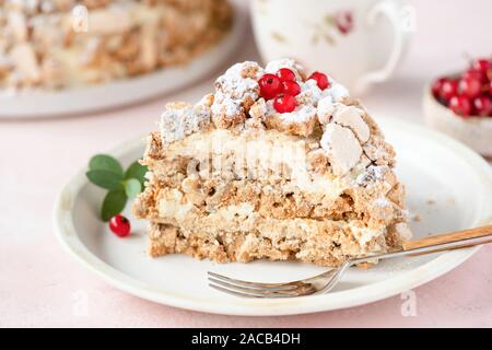 Haselnuss Daquoise Kuchen oder Kiew Kuchen mit Baiser Schichten und Vanilla buttercream serviert auf weiße Platte, rosa Hintergrund Stockfoto