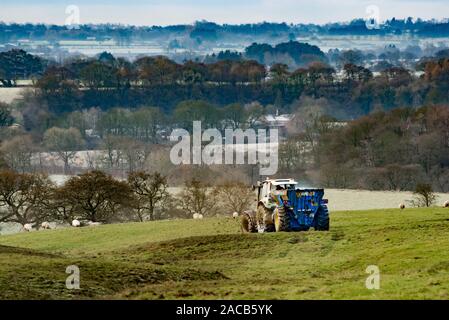 Clitheroe, Lancashire, UK. 2. Dez 2019. Eine ideale Zeit, die wirtschaftsdünger Verbreitung auf dem gefrorenen Feldern Kuh Lade, Clitheroe, Lancashire einen kalten Wintermorgen zu erhalten. Quelle: John Eveson/Alamy leben Nachrichten Stockfoto