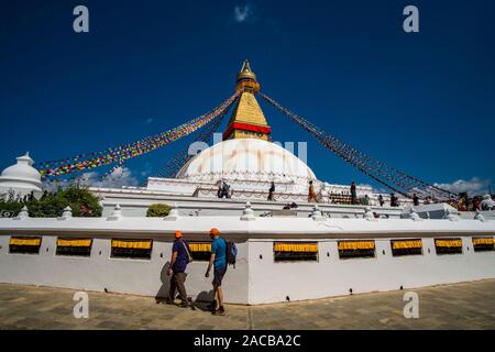 Panoramablick auf die boudha Stupa in der Vorstadt Boudhanath, zwei männliche Touristen um ihn kreisenden Stockfoto