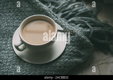 Tasse Kaffee mit Milch auf gemütlichen gestrickt winter Decke, Vintage Style close-up Stockfoto