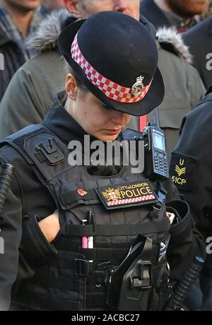 Polizisten an einer Mahnwache in Guildhall Yard, London, die Opfer aus der London Bridge Terroranschlag zu Ehren, wie auch die Mitglieder der Öffentlichkeit und der Rettungsdienste, die ihr Leben riskierten, um anderen zu helfen, nach einer terroristischen trägt eine gefälschte Selbstmord Weste auf des Messers rampage tötet zwei Menschen gingen, wurde von der Polizei am Freitag erschossen. Stockfoto